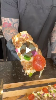 a man holding up a piece of pizza with toppings on it, while another slice has been cut in half