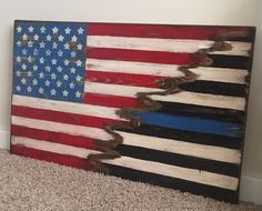 an american flag made out of wooden planks on carpeted floor next to wall