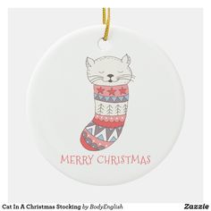 a white ceramic ornament with a cat in a christmas stocking on it