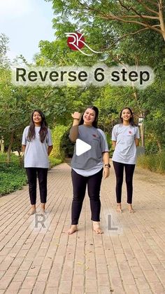 three women in grey shirts and black pants are walking down a brick path