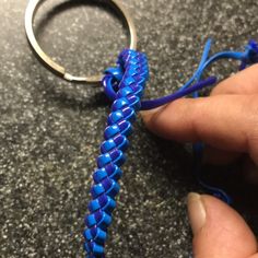 a person holding a blue string wrapped around a metal ring