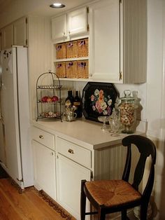 a kitchen with white cabinets and an old fashioned chair in front of the counter top