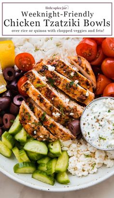 a white plate topped with chicken, rice and veggies next to olives