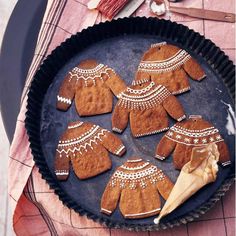 a pan filled with cut out gingerbreads on top of a table next to utensils