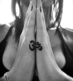 a woman is holding her hands together with the word om on their chest and hand