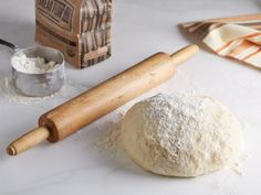 a ball of dough next to a rolling pin on a white counter with a sign that says, muttakata pratik biagier