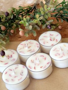 six white candles sitting on top of a table