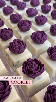 purple flowers are on top of white chocolates in the shape of squares with words that read, bombom de cookies