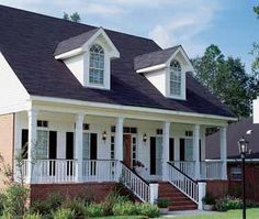 a white house with black roof and porch