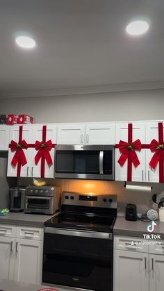 a kitchen decorated for christmas with red bows