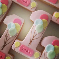 decorated cookies in the shape of letters and balloons