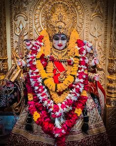 the statue is decorated with flowers and garlands