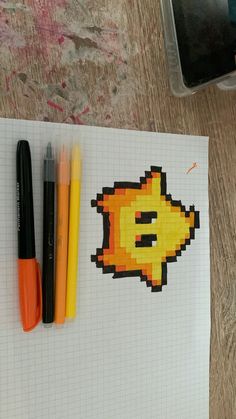 some pens are laying on top of a piece of paper with an image of a pacman