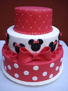 a red and white cake with minnie mouse decorations