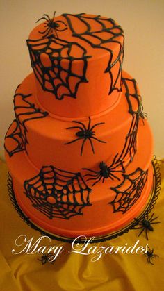 a three tiered cake decorated with spider webs