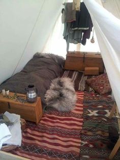 an unmade bed in a teepee with blankets and pillows