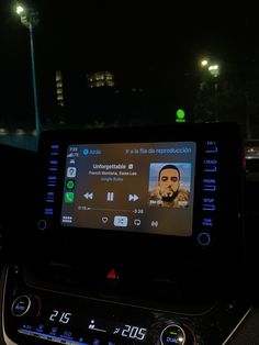 the dashboard of a car with an electronic device on it's display and lights in the background