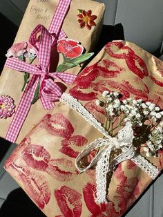 two wrapped presents sitting in the back seat of a car with pink ribbon and flowers on them