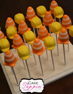 there are many orange and yellow candy cones on sticks