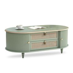 an oval coffee table with two drawers and wicker baskets on the top, in green