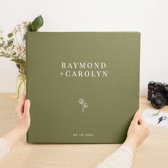 a person holding up a book with the words,'raymond + garolyn '