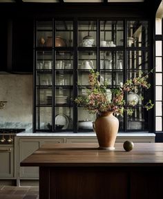 a vase filled with flowers sitting on top of a wooden table next to a window