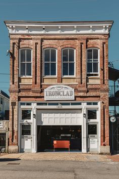 an old brick building with two garages on the front and one above it's door