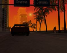 a car driving down a street next to tall buildings and palm trees in the background