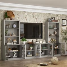 a living room filled with furniture and a flat screen tv on top of a wooden shelf