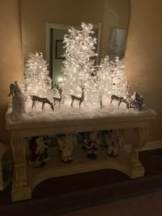 a christmas scene with white lights and reindeer figurines in front of a mirror