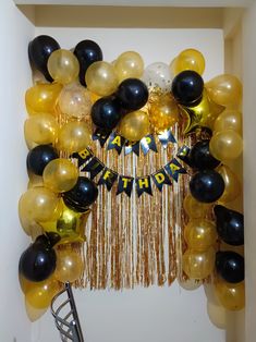 balloons and streamers decorate the entrance to a birthday party in gold, black, and white