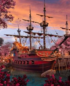 a painting of a pirate ship in the water with pink flowers on it's side