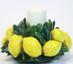 a candle is surrounded by lemons and leaves