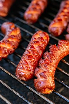 hot dogs and sausages cooking on a grill