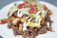 a close up of a plate of food with meat and vegetables on it, including cheese