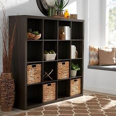 a bookcase with baskets and plants on it