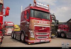 a red volvo truck parked next to other trucks