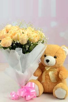 a teddy bear holding a bouquet of yellow roses