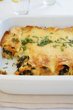 a casserole dish with spinach and cheese in it sitting on a table