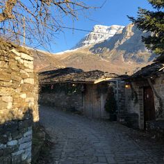 an old cobblestone street with mountains in the background