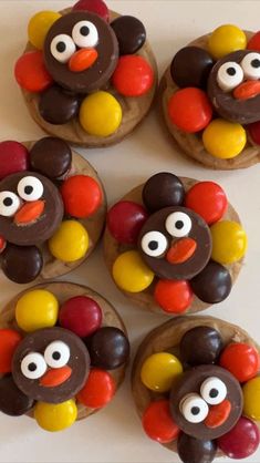 four cookies decorated to look like turkeys with googly eyes and chocolate candies