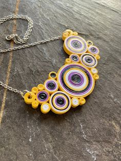 I love circles, especially concentric ones. Theres something I find soothing about groupings of them and the organic shapes they form. Thats what I tried to capture in these quilled necklaces. Each circle is made from layer upon layer of hand rolled (quilled) paper strips that are then arranged into a bib. They have been sealed twice in waterproof varnish for durability. That being said, these are not made to be submerged in water but they will hold up to daily wear nicely. I made this series or necklaces based off of pride flags to show my love and support for this community.  Be proud of your identity, you are loved! Spiral Multicolor Necklace Gift, Multicolor Spiral Necklace Gift, Handmade Yellow Circular Jewelry, Multicolor Circle Necklace Gift, Multicolor Circle Necklace For Gift, Modern Handmade Circular Necklace, Quilling Necklace, Quilling Jewellery, Paper Quilling Jewelry