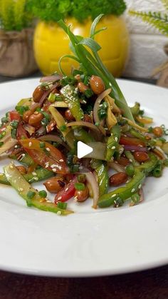 a white plate topped with green beans and onions