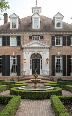 a large brick building with a fountain in front of it and lots of windows on the side