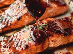 a person pouring sauce on top of salmon