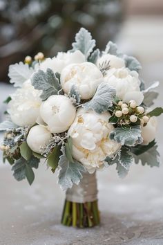 a bridal bouquet with white flowers and greenery