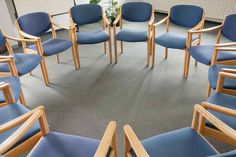 a circular arrangement of chairs and tables in a room with carpeted flooring on the ground