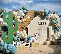 there is a fake cactus on the side of this building with balloons all over it