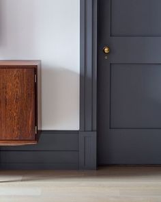 an empty room with a wooden cabinet next to the door