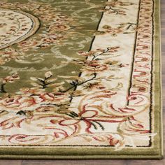 a green rug with red and white designs on the bottom, sitting on a wooden floor